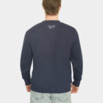 Model wearing the Last Bucks The Signature Sweater in Navy, back view with knitted neck logo