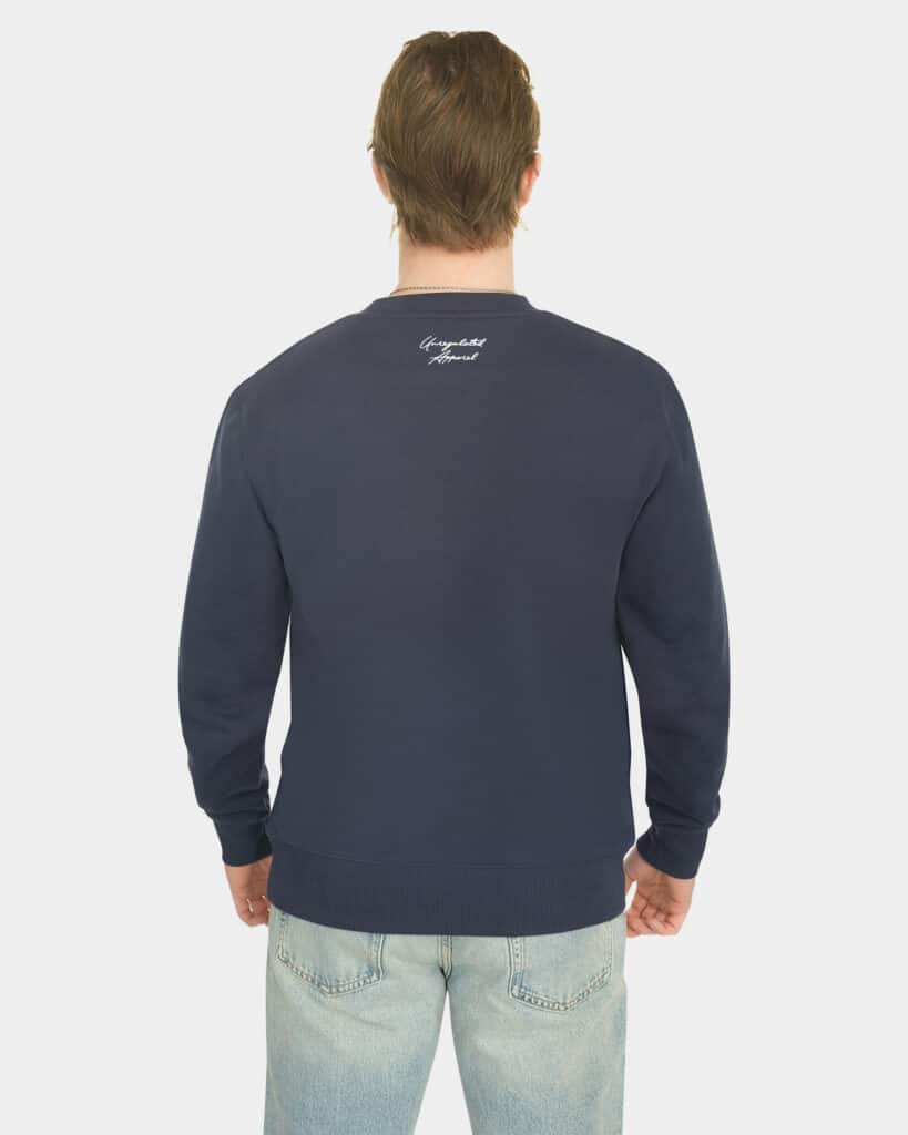 Model wearing the Last Bucks The Signature Sweater in Navy, back view with knitted neck logo