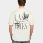 Model wearing the Uncaged Birds Tee in Off-White, back view with large “LAST BUCKS” graphic and flying birds artwork