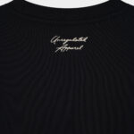 Close-up of the knitted "Unregulated Apparel" logo at the back neck on The Signature Sweater in Jet Black