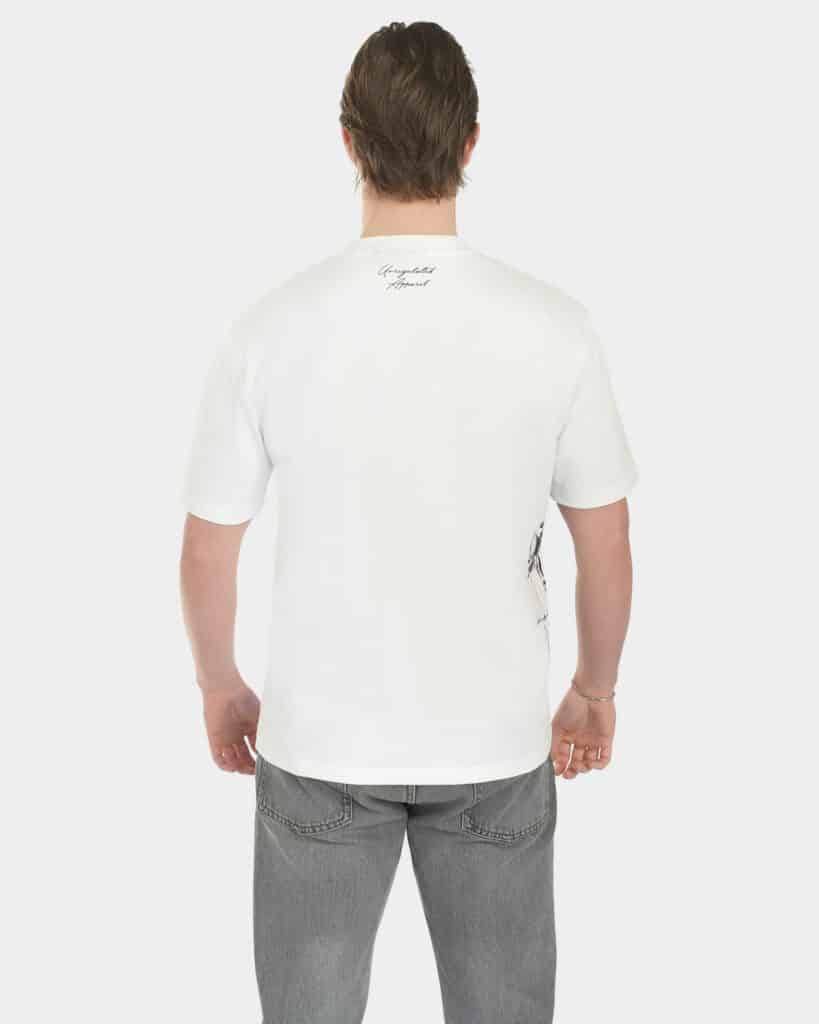 Male model wearing The Balance Side Tee in white, back view, with a small “Unregulated Apparel” script at the back neck and a clean relaxed fit
