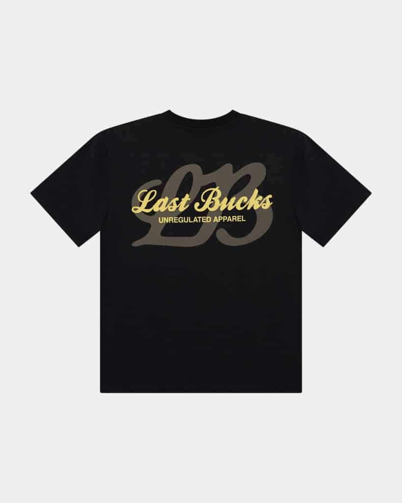 The Script Tee Jet Black - Black t-shirt back view with a large “Last Bucks” script logo in gold, “UNREGULATED APPAREL” text, and an oversized tonal “LB” graphic behind it