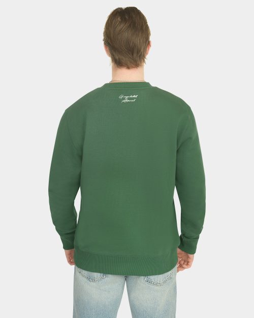 Model wearing the Last Bucks The Signature Sweater in Hunter Green, back view with knitted neck logo