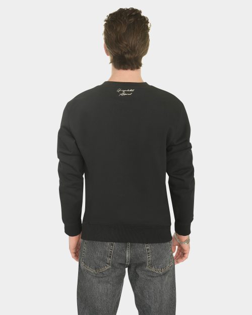 Model wearing the Last Bucks The Signature Sweater in Jet Black, back view with knitted neck logo