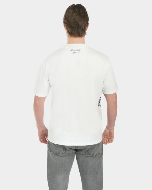 Male model wearing The Balance Side Tee in white, back view, with a small “Unregulated Apparel” script at the back neck and a clean relaxed fit