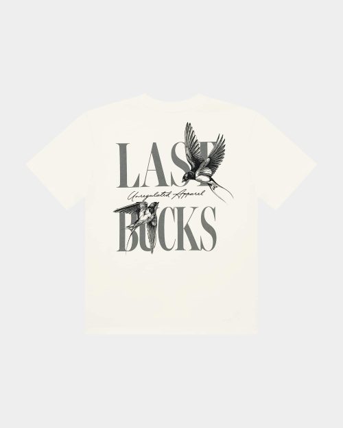 Uncaged Birds Tee Off-White - back view with large LAST BUCKS graphic, “Unregulated Apparel” script, and flying bird illustration